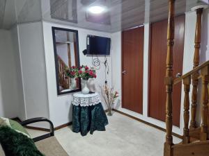 przedpokój ze stołem z kwiatami i telewizorem w obiekcie Habitación baño privado garaje moto, Manizales w mieście Manizales