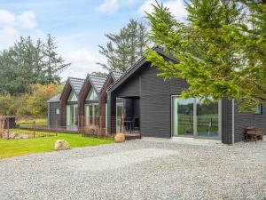 a house with black siding and a gravel driveway at 12 person holiday home in Ansager-By Traum in Ansager
