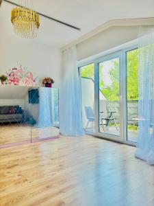 a living room with a wooden floor and a chandelier at Apartament Premium Cichowo in Cichowo