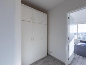 a bedroom with white cabinets and a window at Modern studio in Middelkerke with views in Middelkerke