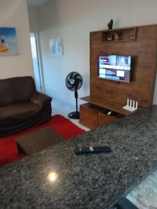 - une télécommande assise sur un comptoir dans le salon dans l'établissement Casa de praia verde mar, à Itanhaém