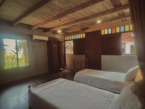 Un dormitorio con dos camas y dos ventanas. en LEJU 21 樂居 Explore Malacca from a riverside house, en Melaka