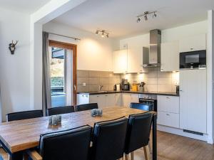 a kitchen and dining room with a wooden table and chairs at Chalet in French Alps with Mountain Views in Abondance