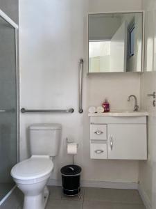 a bathroom with a toilet and a sink and a mirror at Pousada Fornerolli in Penha