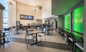 a dining room with tables and chairs and a green wall at Chateau Bedford Trademark Collection by Wyndham in Halifax