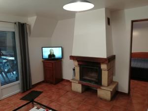 ein Wohnzimmer mit Kamin und Fernseher in der Unterkunft Apartment in Quend near the Sea in Quend