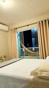 a bedroom with a bed and a window with a view at Canto da Praia Aconchego in Penha