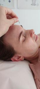 a man laying on a bed with a needle in his head at Zen Pousada in Telêmaco Borba