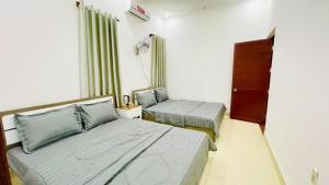 ein Hotelzimmer mit zwei Betten und einem Fenster in der Unterkunft Lucky 2 Hotel in Trà Vinh