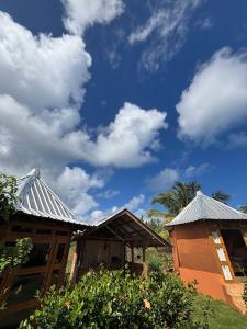 a couple of buildings with a blue sky and clouds at Atabeba in Las Galeras