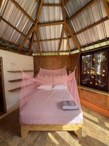 a bedroom with a pink bed in a room at Atabeba in Las Galeras