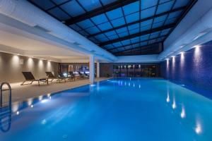 a large pool in a hotel with chairs and tables at Fraser Place Antasya Istanbul in Istanbul