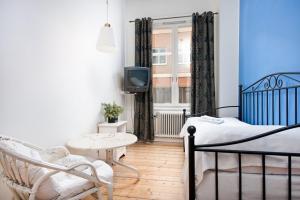 a bedroom with a bed and a tv and a chair at Pensionat Svea in Östersund