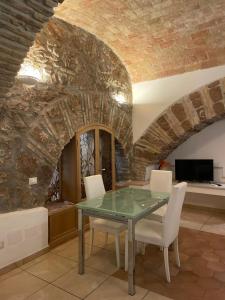 a dining room with a glass table and white chairs at Roman times experience in Monti area in Rome