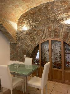a dining room with a table and chairs and a stone ceiling at Roman times experience in Monti area in Rome