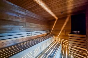 a wooden bench in a sauna with lights on it at Hanza Tower Apartment no 2210 - 22nd floor, swimming pool, jacuzzi, panorama view in Szczecin