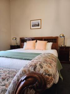 Un dormitorio con una cama grande con cabecero de madera. en The Macquarie Hobart, en Hobart