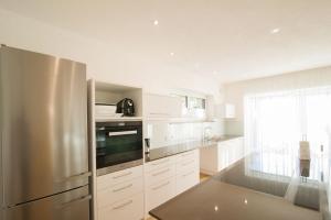 a kitchen with a stainless steel refrigerator and white cabinets at Lavendelhof in Appiano sulla Strada del Vino