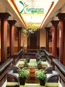 a building with a staircase with potted plants in it at Karithanam Ayur Farms in Vaikom