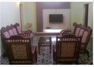 a room with chairs and a table and a television at Karithanam Ayur Farms in Vaikom