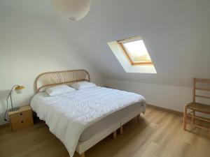 a bedroom with a bed and a skylight at Charmante maison proche plage à Groix, 2 chambres - FR-1-813-3 in Groix
