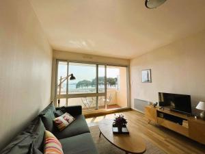 a living room with a couch and a television at Appartement Bénodet 4 pers, proche plage - FR-1-481-169 in Bénodet