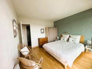 a bedroom with a white bed and a green wall at Appartement Bénodet 4 pers, proche plage - FR-1-481-169 in Bénodet