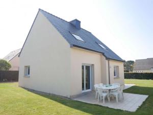 a small white house with a table and chairs at Erdeven - Maison lumineuse 5 pièces avec jardin fermé - FR-1-479-188 in Erdeven