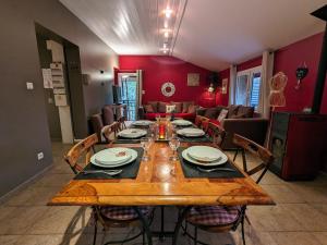 a dining room with a wooden table and a couch at Gîte calme avec jardin zen, piscine et randonnée au Parc des Vosges - FR-1-589-763 in Cornimont