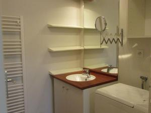a small bathroom with a sink and a mirror at Charmant T2 à Étel avec terrasse, parking et proche plage - FR-1-479-194 in Étel