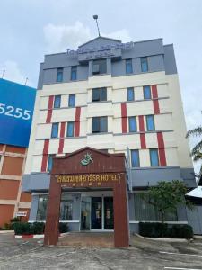 a tall building with a sign on top of it at SR Hotel in Ban Tha Kup