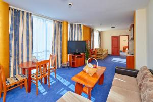 a living room with a couch a table and a television at Petar and Pavel Hotel & Relax Center in Pomorie