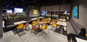 a restaurant with tables and yellow chairs and a bar at Fraser Place Antasya Istanbul in Istanbul