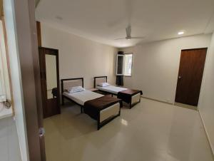 SāngliHotel Vishram guesthouse lodge的有两张床和一面镜子的房间