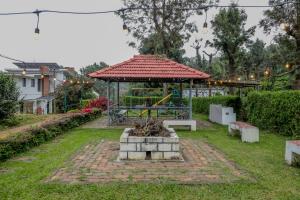 a gazebo with a bench in a yard at Shola Gardens , Kotagiri in Kotagiri