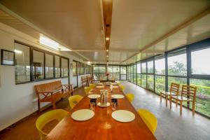 a dining room with tables and chairs and windows at Shola Gardens , Kotagiri in Kotagiri +67 photos