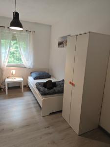 a small bedroom with a bed and a cabinet at Work and stay IaM 90 qm 3 Schlafzimmer 6 betten mit Balkon und kraftraum in Plettenberg