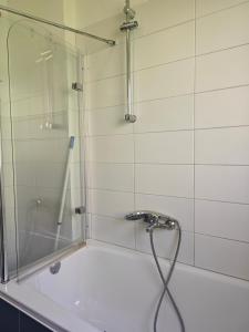 a shower with a glass door next to a tub at Work and stay IaM 90 qm 3 Schlafzimmer 6 betten mit Balkon und kraftraum in Plettenberg