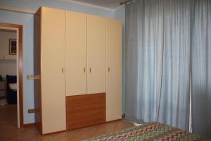 チェチナにあるAppartamento Via Fuciniのベッドルーム1室(ベッド1台付)、大きなキャビネットが備わります。