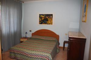 チェチナにあるAppartamento Via Fuciniのベッドルーム1室(カラフルな毛布付きのベッド1台付)