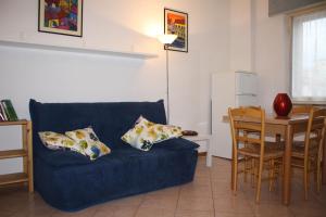 a living room with a blue couch and a table at Appartamento Via Fucini in Cecina