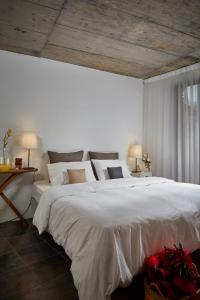 1 dormitorio con 1 cama blanca grande y 2 lámparas en Casa De Janeiro, en Janeiro de Cima