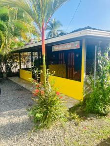 a yellow bus stop with a palm tree at Caribbean Comfort in Puerto Viejo