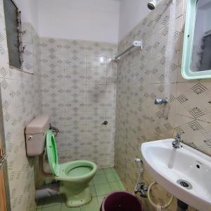 a bathroom with a green toilet and a sink at SUNNY CLIFF BEACH Stay in Arambol +112 photos