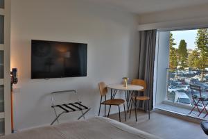 a hotel room with a bed and a table and chairs at Dee Why Beach - Surfrider Studio 22 in Deewhy