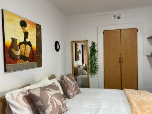 a bedroom with a bed with a painting on the wall at The Fern Corner Guest House Unit 2 in Letaba