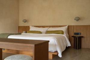 ein Schlafzimmer mit einem großen Bett mit weißer Bettwäsche in der Unterkunft Calista Studios SATU Tasteful 1 BR home in peaceful jungle, 10 mins away from the buzz of Uluwatu in Uluwatu