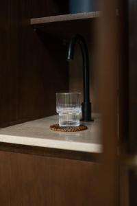 ein Glas auf einer Theke neben einem Waschbecken in der Unterkunft Calista Studios SATU Tasteful 1 BR home in peaceful jungle, 10 mins away from the buzz of Uluwatu in Uluwatu