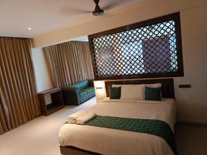 una camera da letto con un letto con una grande finestra di Hotel Rameswaram Grand a Rāmeswaram