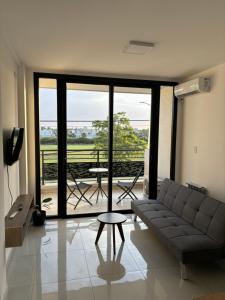 a living room with a couch and a large window at Dalcar Apart in Río Cuarto